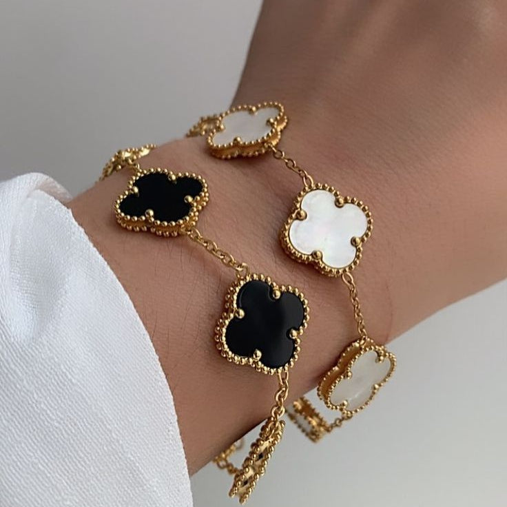 Adjustable black clover bracelet and white clover bracelet set.
