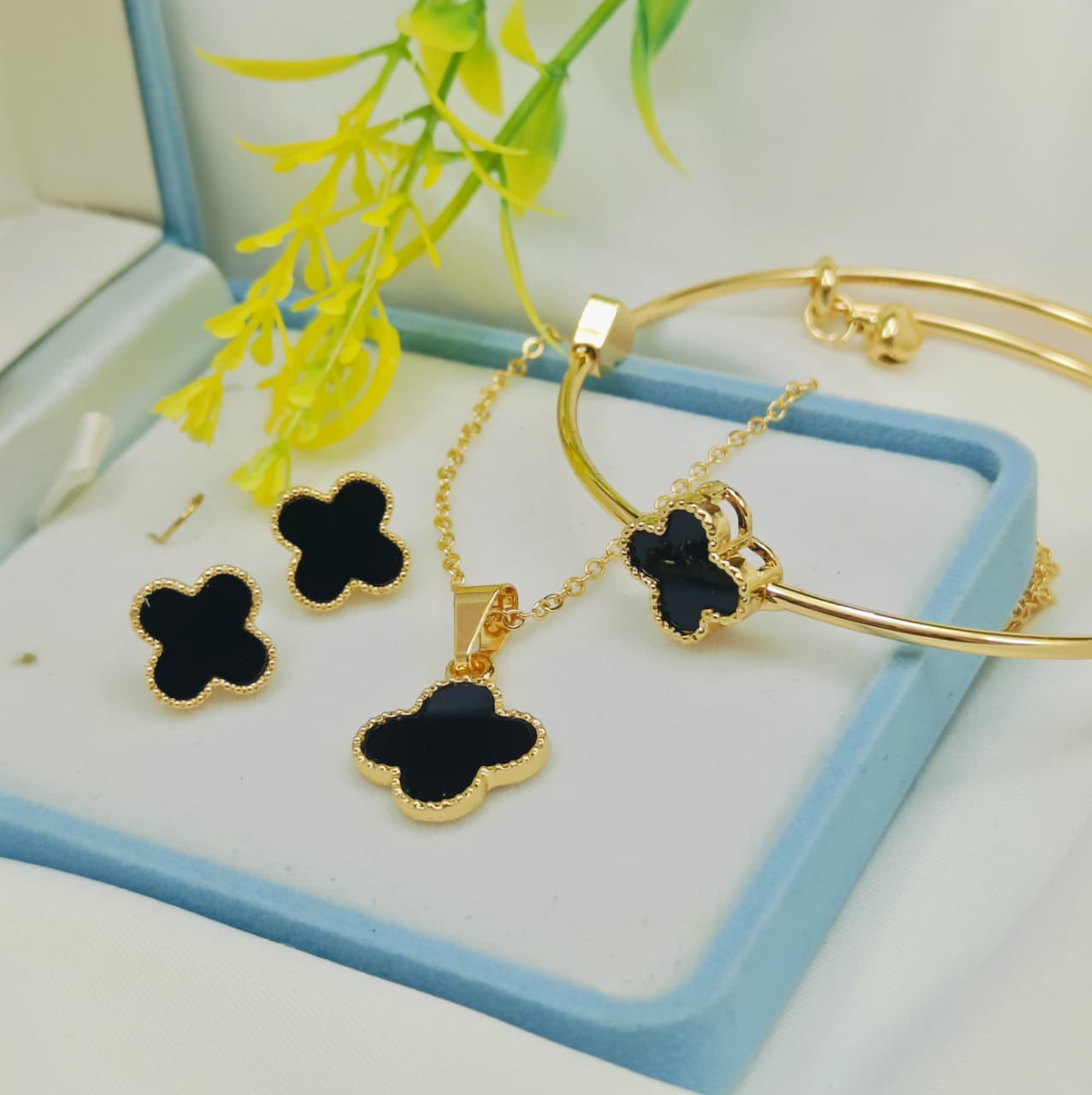 Black clover gold jewelry set with necklace, earrings, and adjustable bangle