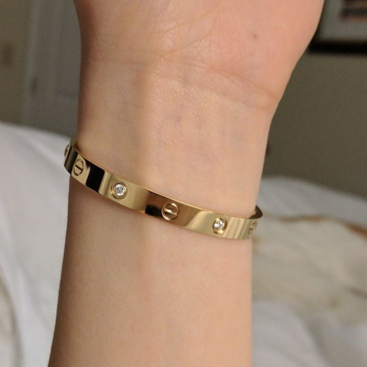 Trendy Cartier embossed stamp handcuff, stylish unisex wrist accessory.