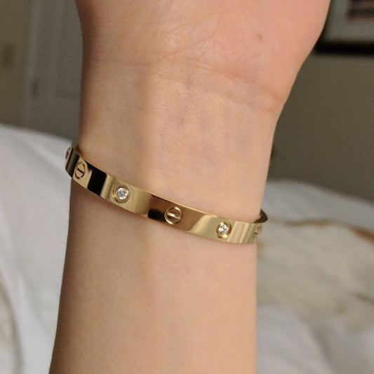 Trendy Cartier embossed stamp handcuff, stylish unisex wrist accessory.