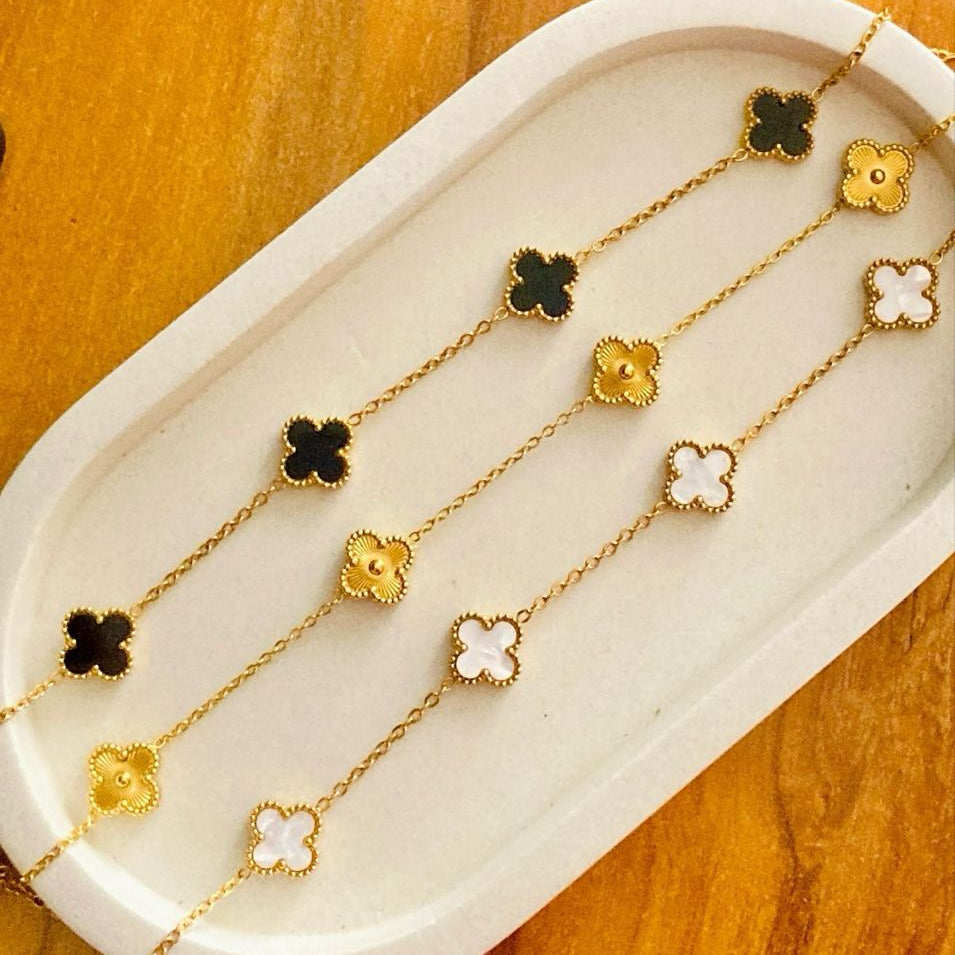 A collection of elegant gold-plated flower bracelets with black and white enamel flowers