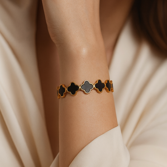 Elegant gold-plated bracelet featuring black enamel clover design