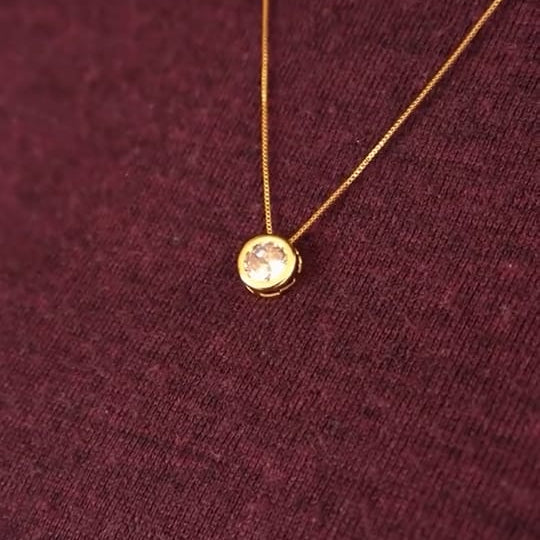 Close-up of delicate gold chain with solitaire pendant for women