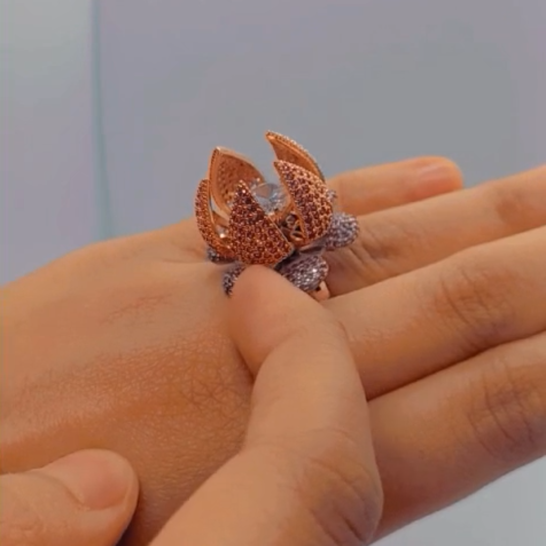 Luxury lotus flower cocktail ring with crystal petals in pink and purple on hand.