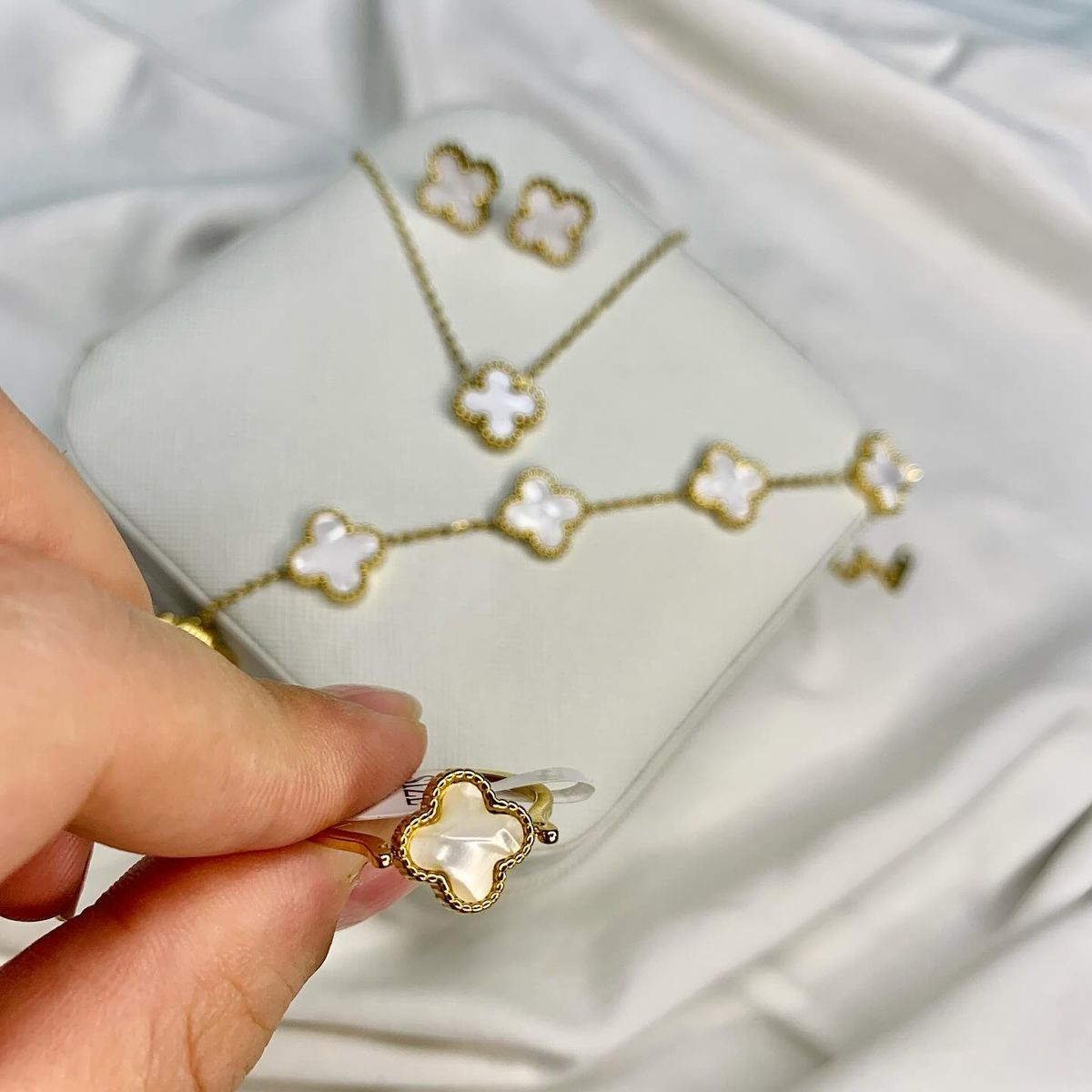 White clover gold jewelry set with earrings, necklace, bracelet, and ring