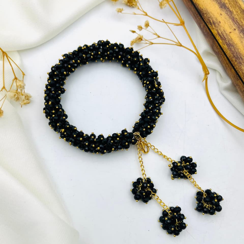 Elegant black beaded waterproof bracelet with golden accents and dangling charms