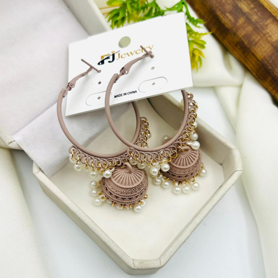 A pair of beige hoop earrings with intricate jhumka-style pendants and small pearl detailing.