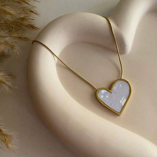 Trendy white heart-shaped necklace with gold border, premium fashion accessory.