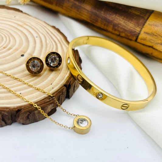 Gold-tone bracelet, matching necklace with crystal pendant, and round stud earrings with clear crystals