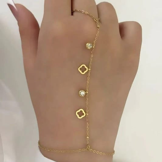 Gold-plated hand chain bracelet with floral and crystal charms connecting ring to wrist