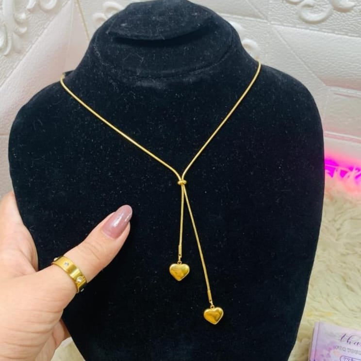 Gold waterproof double heart drop necklace displayed on black jewelry stand with adjustable sliding chain
