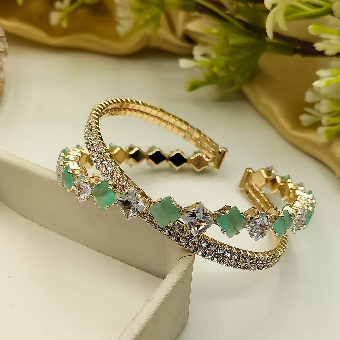 “Gold bracelet pair with sparkling crystals and emerald gems – fashion jewelry for women”