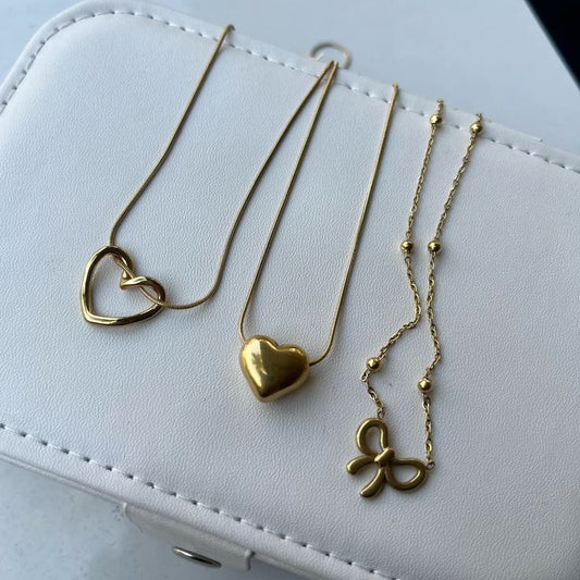 Gold waterproof necklace set with heart and bow.