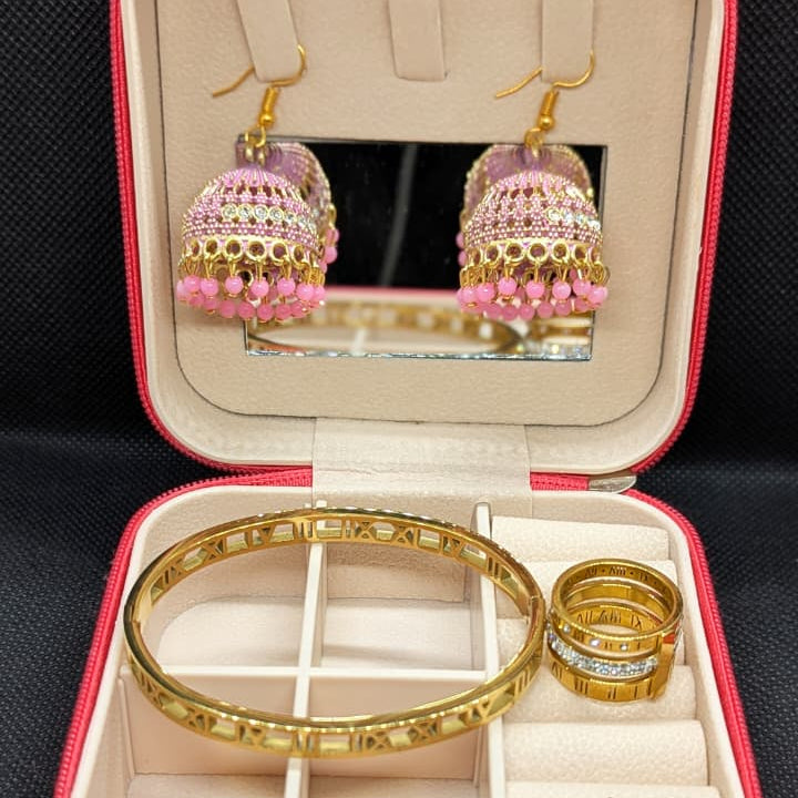 Gold jewelry set featuring pink beaded earrings, a matching bangle, and stacked rings in a stylish jewelry box.