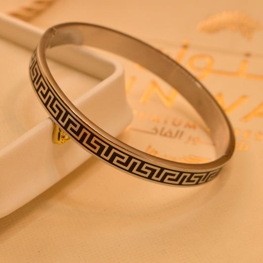 Stainless steel bangle featuring a Greek key design