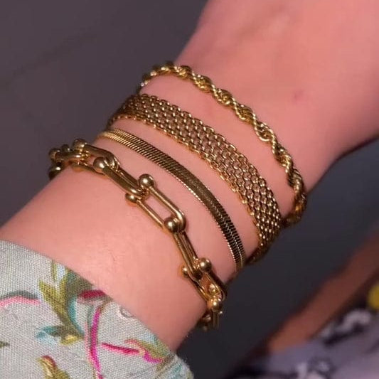 Multiple gold-plated bracelets with different chain designs, including twisted, link, and flat styles.